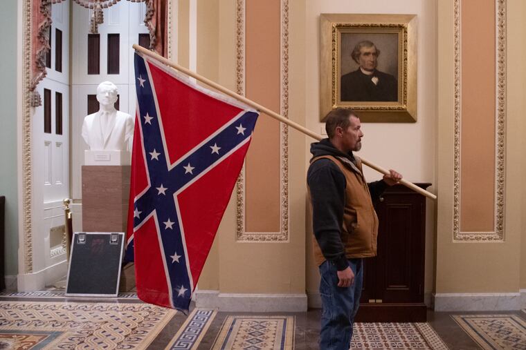 A supporter of President Donald Trump holds a Confederate flag outside the Senate Chamber during a rampage in the U.S. Capitol in Washington, D.C., on Jan. 6, 2021.