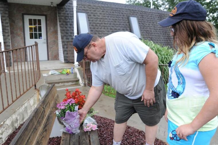 Clay Borger and his daughter Breanna, 11, of Saylorsburg, Pa., leave flowers at the Ross Township municipal building in Saylorsburg on Wednesday, Aug. 7, 2013. Three people were shot to death and one critically wounded during a meeting at the Ross Township municipal building in Saylorsburg, Pa. Monday night. Rockne Newell has been charged with the killings. (AP Photo/Pocono Record, David Kidwell)