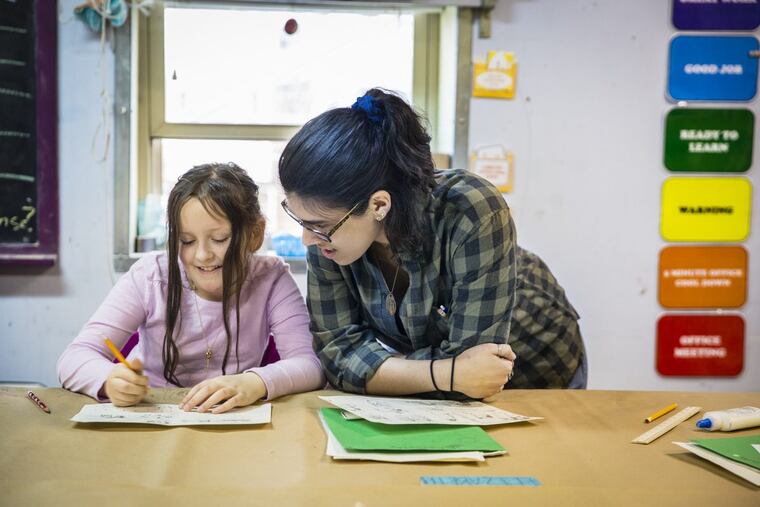 Katherine Videira, lead art teacher of the 2nd to 5th graders, helps student Elizabeth Pavlica, 9, with her comic book at Portside Arts Center in Port Richmond. Portside, which has provided arts programming to the community since 2008, may have to close its doors.