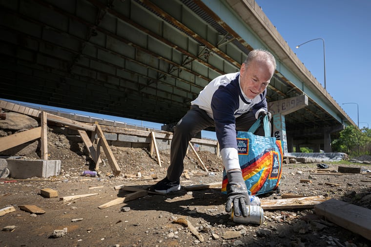 Patrick Shanahan collects aluminum cans for recycling at FDR Park in South Philadelphia. Shanahan, who started a recycling program at Roman Catholic High School, began picking up trash after retiring during the pandemic and recovering from a botched surgery. He has continued the effort since.