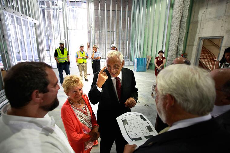 Philanthropists Nicholas and Athena Karabots visiting the pavilion construction site at the Franklin Institute in September; Dennis Wint, president and CEO, holds a floor plan for the new 53,000-square-foot wing, housing a new brain exhibit, classrooms and conferencing technology. The couple have given the institute $10 million - its biggest gift ever- motivated by the chance to use science as a positive beacon for children "beyond what they see every day in their neighborhood," Nicholas Karabots said.