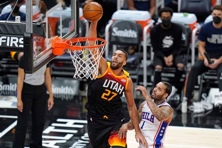 Utah Jazz center Rudy Gobert (27) dunking the ball in front of 76ers forward Mike Scott in the first half of Monday's game.
