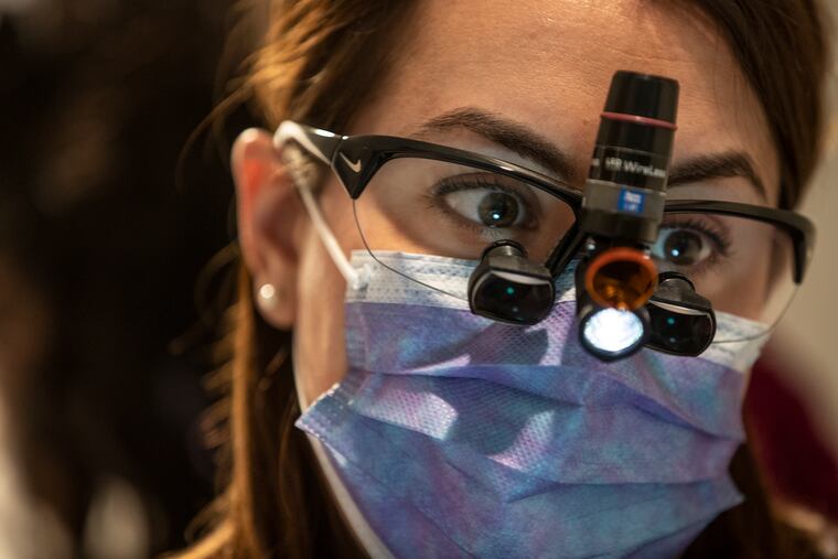 Dentist Janine Burkhardt uses a light attached to her magnifying glasses instead of having a large overhead light in the dental services area of the Hub of HOPE, which is Project HOME's direct-service location in the Suburban Station concourse.
