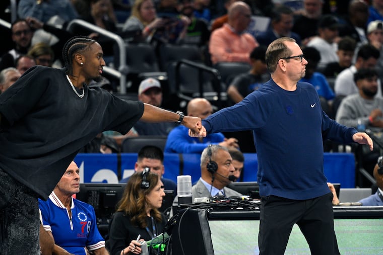 Sixers coach Nick Nurse (right) gets a fist bump from injured guard Tyrese Maxey during the loss to the Magic on Friday.