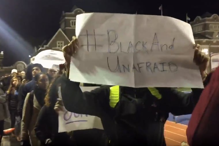 As halftime begins at Franklin Field, Penn students march in front of the seats chanting "Black Lives Matter!" and carrying a range of signs.