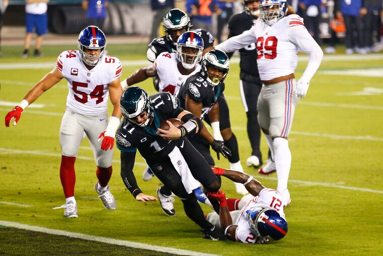 Eagles quarterback Carson Wentz dives into the end zone for a first-quarter touchdown past New York Giants safety Jabrill Peppers on Thursday.
