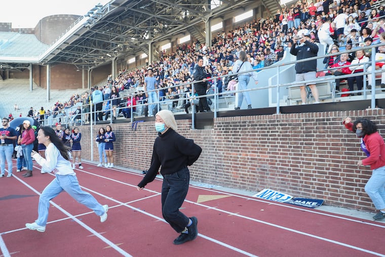 Protesters with Fossil Free Penn run from the stands to take over the field during halftime of a game between Penn football and Yale at Franklin Field in Philadelphia on Saturday. Many were arrested.