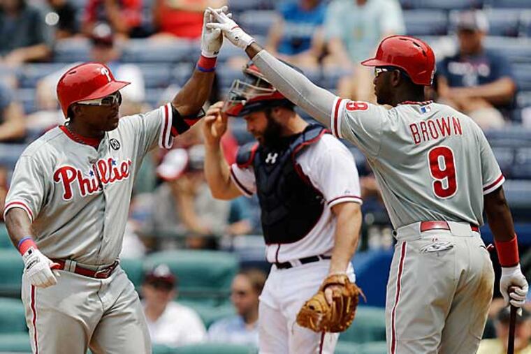 Marlon Byrd, left, is high-fived by teammate Domonic Brown after hitting a home run in the eighth inning of a baseball game against the Atlanta Braves, Wednesday, June 18, 2014, in Atlanta. (David Goldman/AP)