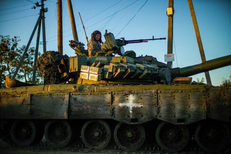 Ukrainian servicemen drive a tank as they cross Oskil village, Ukraine, Thursday, Oct. 6, 2022.