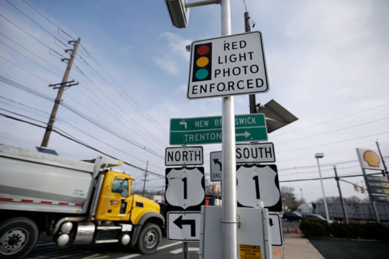 A truck passes a red-light photo enforcement sign at the intersection of Route 1 and Franklin Corner Road in Lawrence Township, N.J. (AP Photo/Mel Evans)