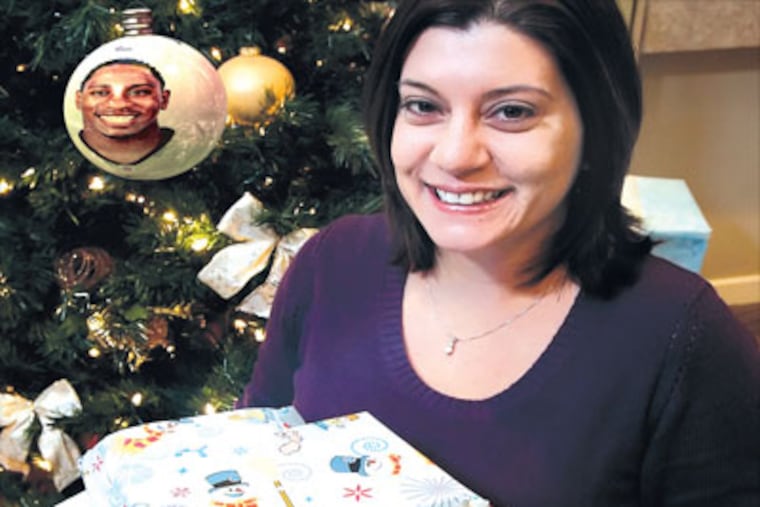 Jennifer Santoro with the Christmas presents Ellis Hobbs bought for her family at Toys 'R' Us. (Photo illustration: Stephen M. Falk / Staff Photographer)