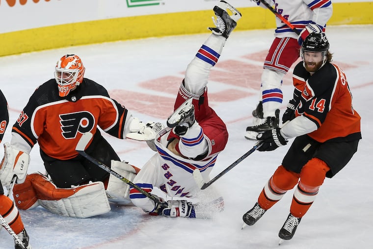 The Rangers' Libor Hajek takes a header between Flyers goalie Brian Elliott and Sean Couturier during the second period on Wednesday.