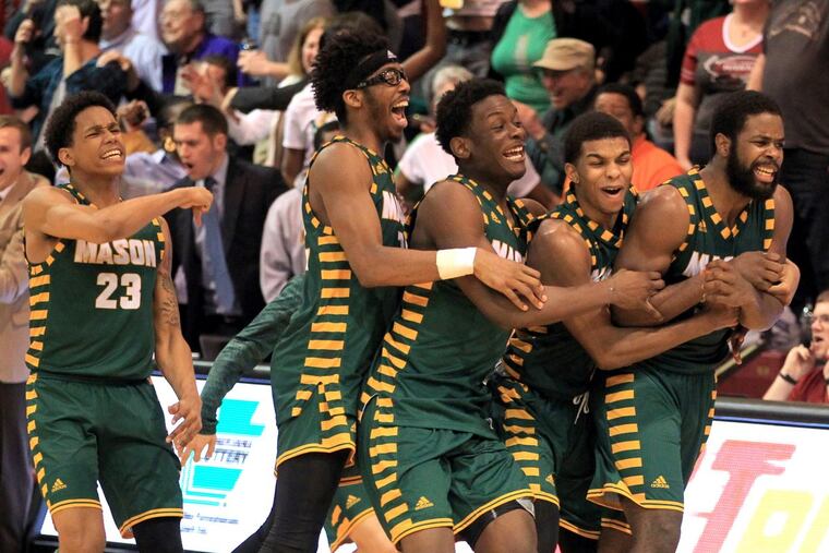 Ian Boyd, right, of George Mason is swarmed by teammates after hitting the game-winning 3-pointer at the buzzer to defeat St. Joseph’s 79-76 at Hagan Arena on Feb.21, 2018. CHARLES FOX / Staff Photographer