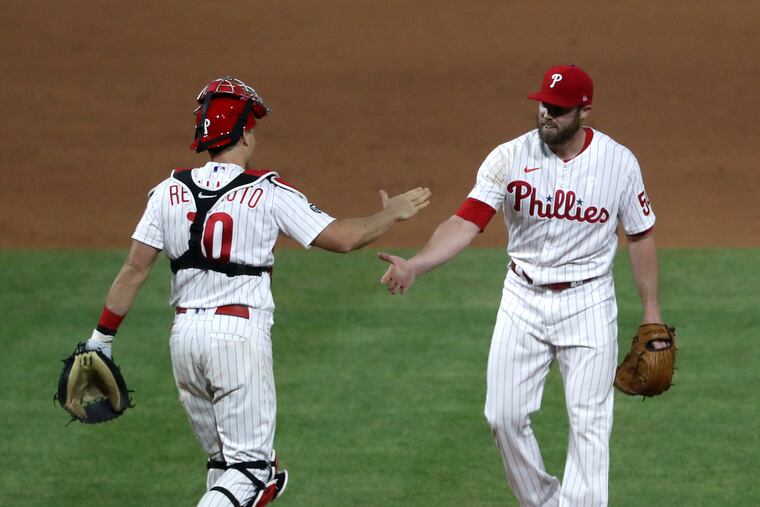 Sam Coonrod, right, of the Phillies is congratulated by J.T. Realmuto after earning the save in a 6-5 victory against the Brewers on May 4, 2021.