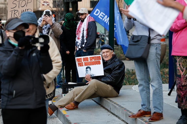 John Rice holds a sign during a rally outside of City Hall in support of Mahmoud Khalil, a pro-Palestinian activist and former Columbia University graduate student, on Monday. Khalil was arrested by immigration authorities, fueling tensions between the Trump administration and student movements over immigration policy. Adding to the unease is a new proposed bill in the state Senate that would compel district attorneys to alert ICE if a defendant is an undocumented immigrant.