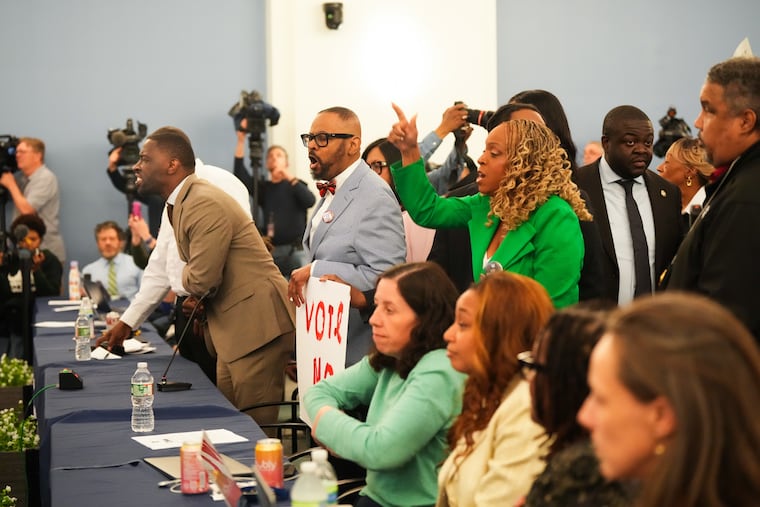 From left, Councilmembers Isaiah Thomas, Curtis Jones Jr., and Jamie Gauthier protest at Thursday's school board meeting as the board prepared to vote on the facilities plan.