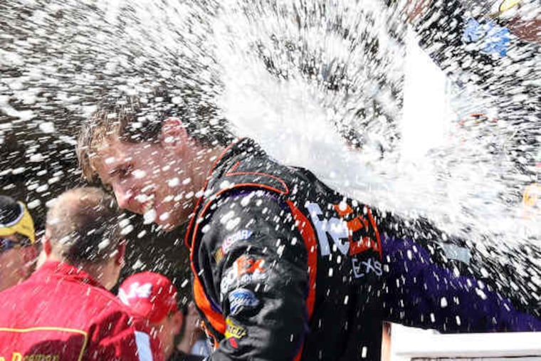 Denny Hamlin gets a champagne shower after winning at Pocono. "I think only half of me was driving the car for most of the day," said Hamlin, whose grandmother died last week.