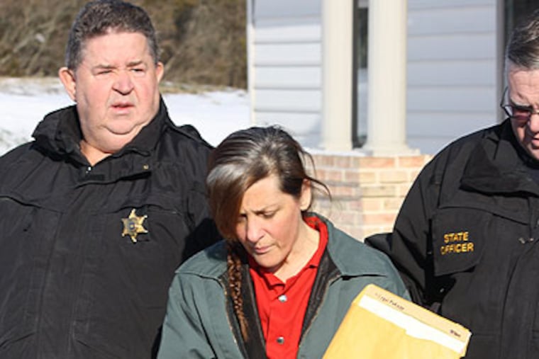 Dorleen Burklund, 49, of Kintnersville, accused of shooting her husband to death at their Bucks County home on Oct. 3, is escorted by constables from district court in Ottsville. Sshe was ordered held for trial Friday on homicide charges. (Photo by Larry King)