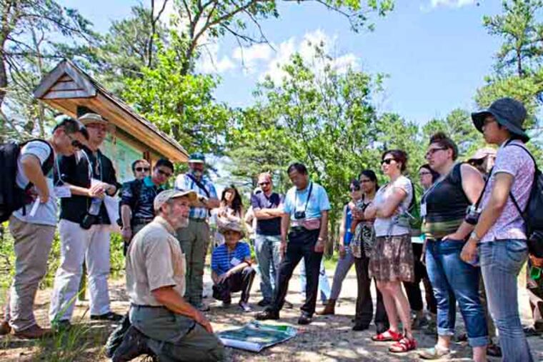 Russell Juelg, N.J. Conservation Foundation (knelling on ground), gives an overview of the Franklin Parker Preserve to the visiting soil ecologists on stop during a tour of the Pine Barrens, June 12, 2013. ( DAVID M WARREN / Staff Photographer )