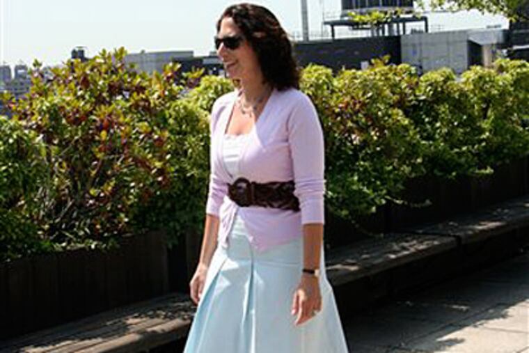 AP writer Lisa A. Flam tries out a wide waist-cinching belt from Belgo Lux. (AP Photo/Ray Kugler)