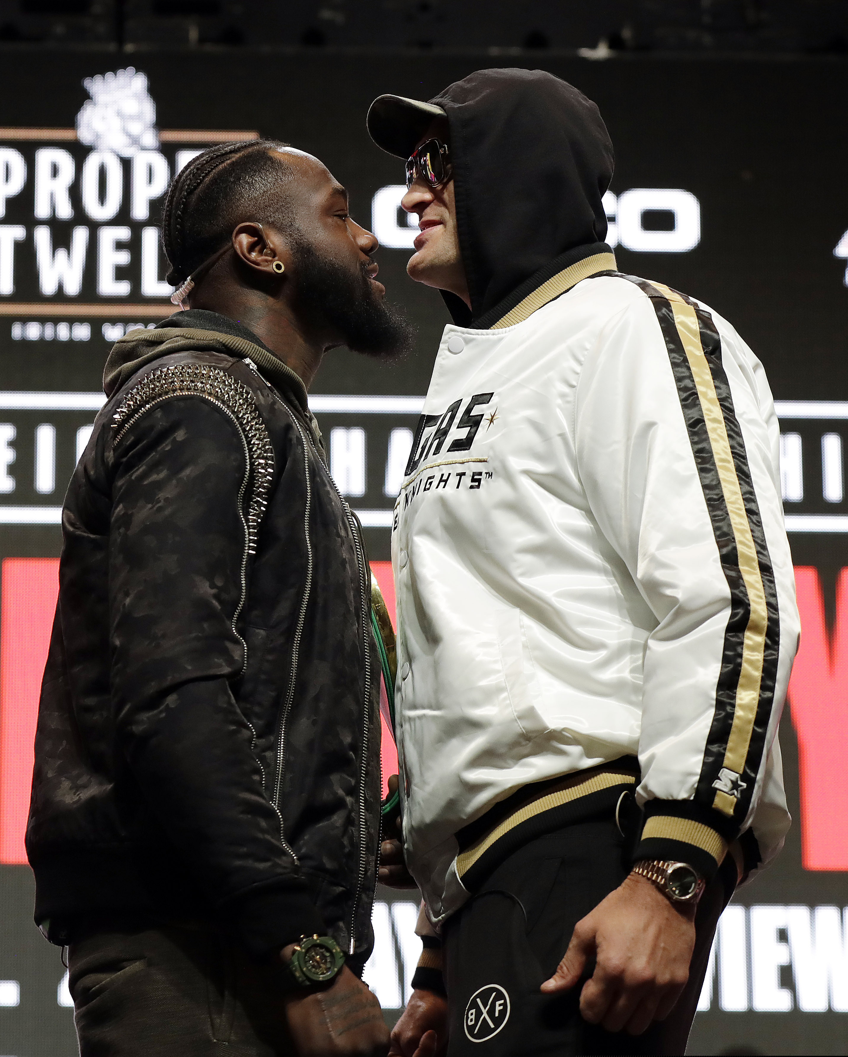 Tyson Fury, of England, right, and Deontay Wilder face off for photographers during a news conference.