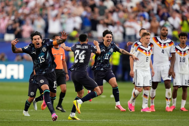 Paraguay's players celebrate while Germany's players mourn at the end of the game.