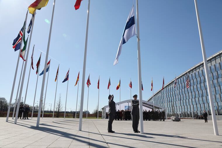 Military personnel raise the flag of Finland during a flag raising ceremony on the sidelines of a NATO foreign ministers meeting at NATO headquarters in Brussels.