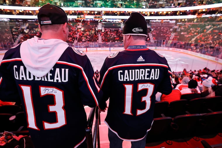 Fans wear the jersey of former Columbus Blue Jacket Johnny Gaudreau, who was killed along with his brother in August while biking in South Jersey.