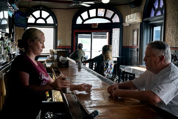 Curran's Irish Inn bartender Maggie Kelly serves patron .Jerry Kennedy (right) Thursday June 15, 2023. Curran's is one of the businesses on State Road that have been most directly impacted in recent days by the closed roads and redirected traffic around the I-95 bridge collapse.