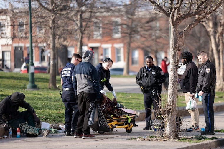 Philadelphia police and emergency workers render aid to a person who possibly overdosed in McPherson Square in March.