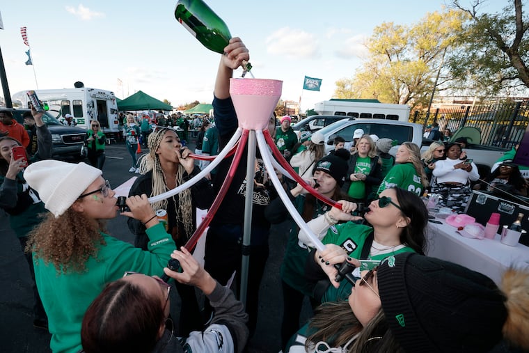 Ladies drink bubbly from the booze funnel during the Girlsgate tailgating event in Lot F2 before the Eagles-Dolphins game at Lincoln Financial Field on Sunday.