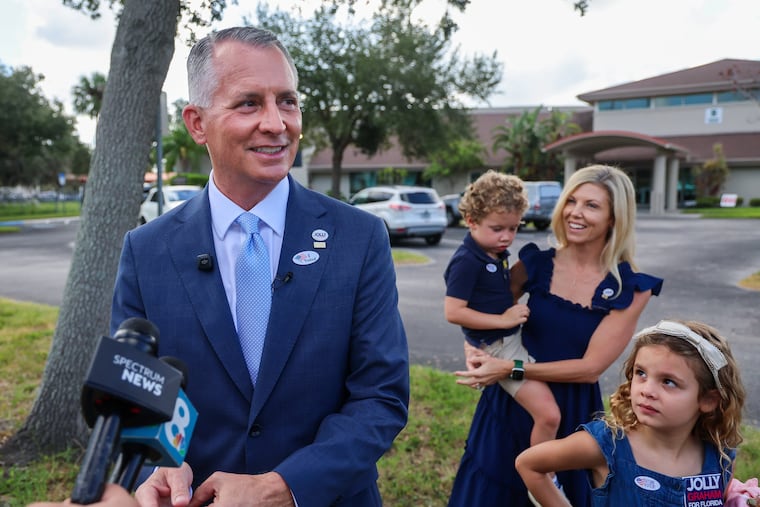 Florida Democratic gubernatorial candidate David Jolly talks with reporters after voting along with his family at their home precinct, the Anona United Methodist Church, Tuesday, Aug. 18, 2026 in Largo, Fla. From left is Jolly, son Teddy, wife Laura and daughter CeCe.
