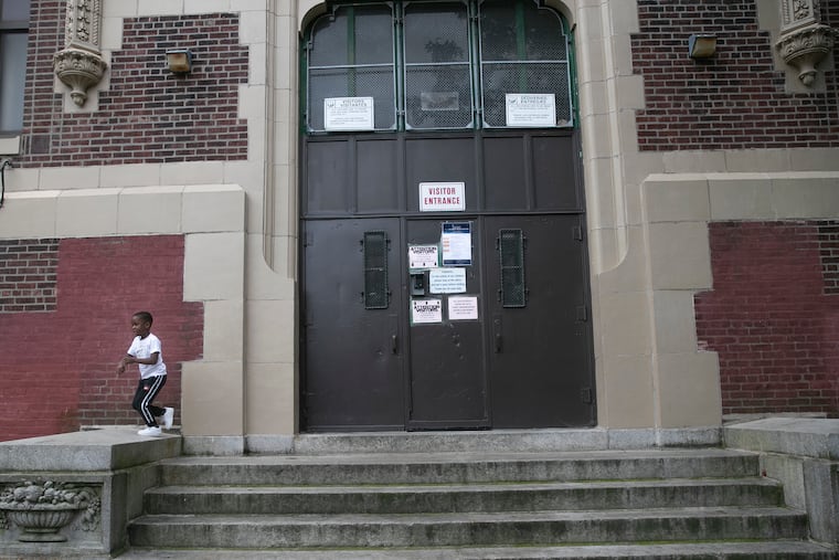 Zahkir Satchell, on his first day of kindergarten, plays outside of the locked doors of Lowell Elementary School in the Olney neighborhood of Philadelphia after picking up books with his mother, Lexus Rowe, on Wednesday, Sept. 2, 2020. Today is the first day of virtual school for 125,000 Philadelphia School District students. Leaders held a press conference outside of the elementary school to demand more funding for public schools floundering under the pressures of COVID-19.
