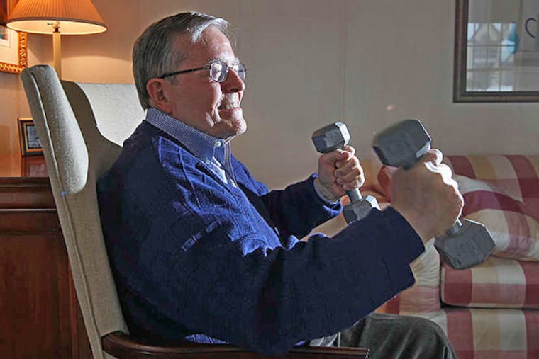 Bob Marshall uses dumbbells to build up his strength as part of his home therapy. Hard work has been the key to the many successes in his life, including recovery from a major illness.