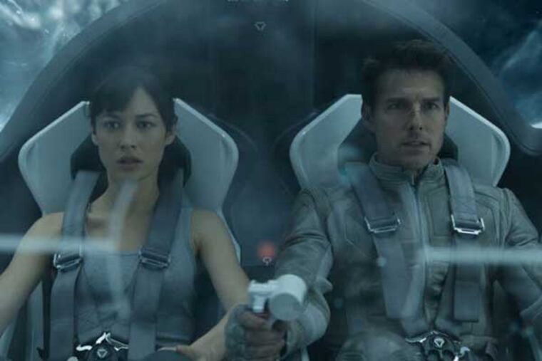 This film publicity image released by Universal Pictures shows Olga Kurylenko, left, and Tom Cruise in a scene from "Oblivion." (AP Photo/Universal Pictures)