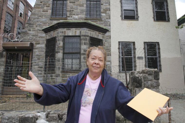 Lucy Aponte of West Tioga near North 8th St. stands in front of a house she bought nearly 11 years ago. The property was allegedly misrepresented in its parcel listing. (Alejandro A. Alvarez / Staff Photographer)
