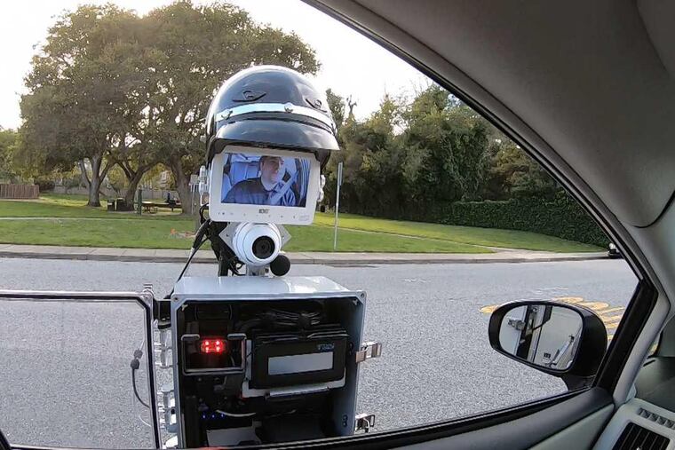 The GoBetween robot extends out from the police vehicle to the car that has been pulled over. When the encounter is done, the entire contraption retracts and the robot returns to the police car. (Handout photo courtesy of SRI International)