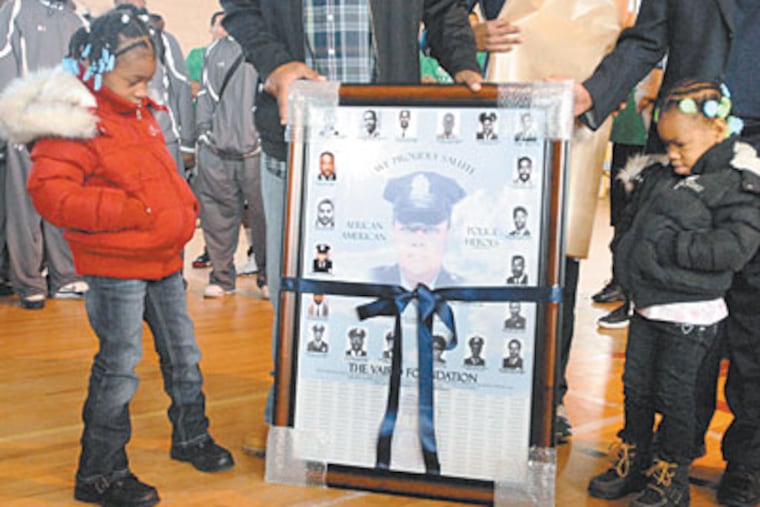 Six-year-old Alexus (left) and three-year-old Chase Caesar look at a plaque dedicated to their grandmother, police officer Lauretha Vaird. (Ron Tarver / Staff Photographe