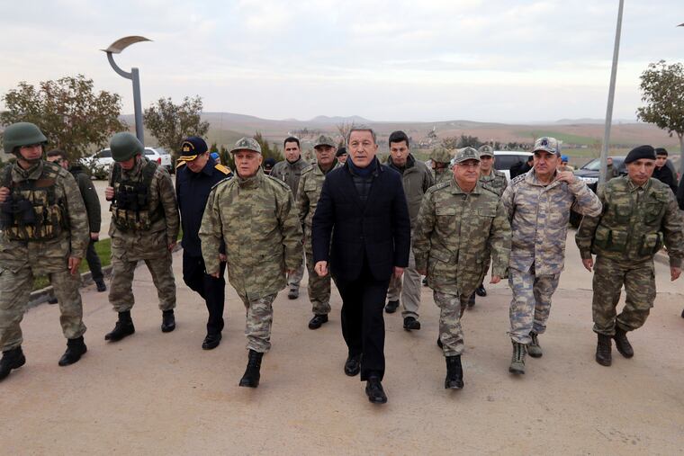 In this photo taken Monday, Dec. 31, 2018, Hulusi Akar, Turkey's Defense Minister and former Chief of Staff, center, and top army commanders walk during a visit to Turkish troops stationed at the border with Syria, in Kilis, Turkey. Russian and Turkish foreign and defense ministers met in Moscow on Saturday to discuss northern Syria as U.S. forces prepare to withdraw and Turkey threatens to launch a military operation against U.S.-backed Kurdish forces controlling nearly a third of the country.(Turkish Defence Ministry via AP)
