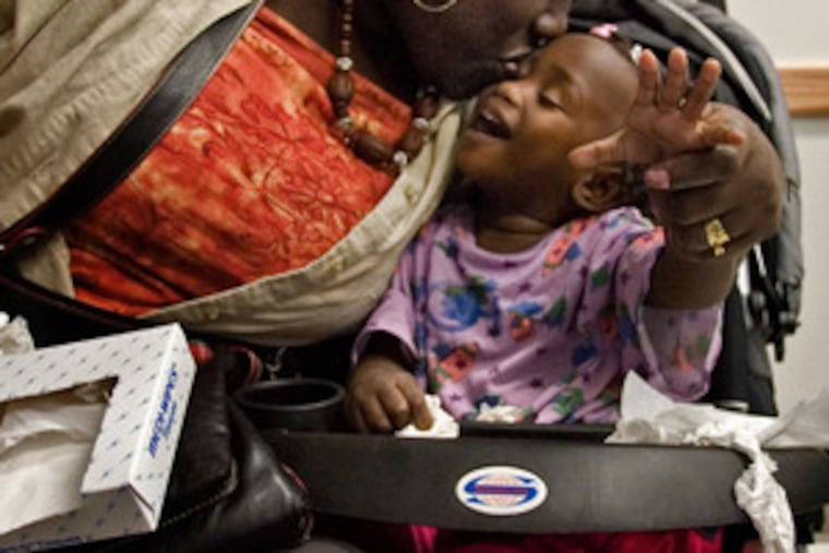Kassiha Francis gets a kiss from her mother, Jeanette, before surgery in October. The toddler from Grenada died last week.