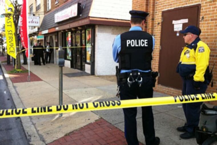Police outside the William Glatz Jewelry store on Rising Sun Avenue, where an employee and robber were killed in a shootout. (Alejandro A. Alavarez / Staff Photographer)