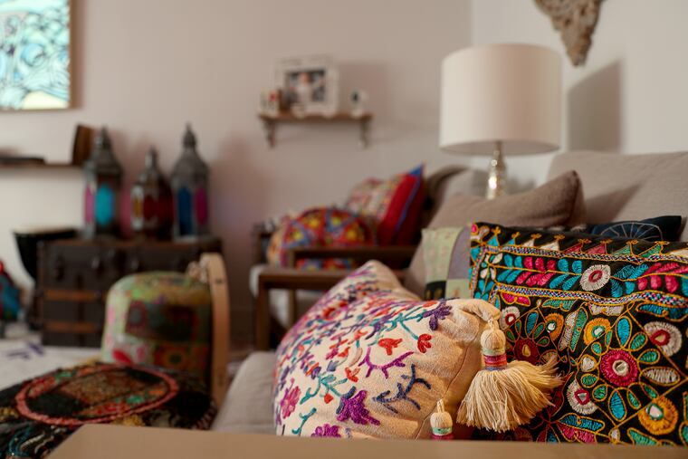 Natalie Jesionka and Ashvin Vijayakumar have filled their Fishtown rowhouse with warmth and color. They've decorated the living room with pillows in cases collected from travels to places like Thailand, India, Burma, and Poland.