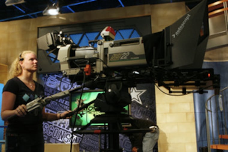 Big Ten Network technician Abigail Rakocy, above, adjusts a camera before the taping of the Big Ten Women's Show in Chicago. At right, host Ann Kreiter puts on her microphone.
