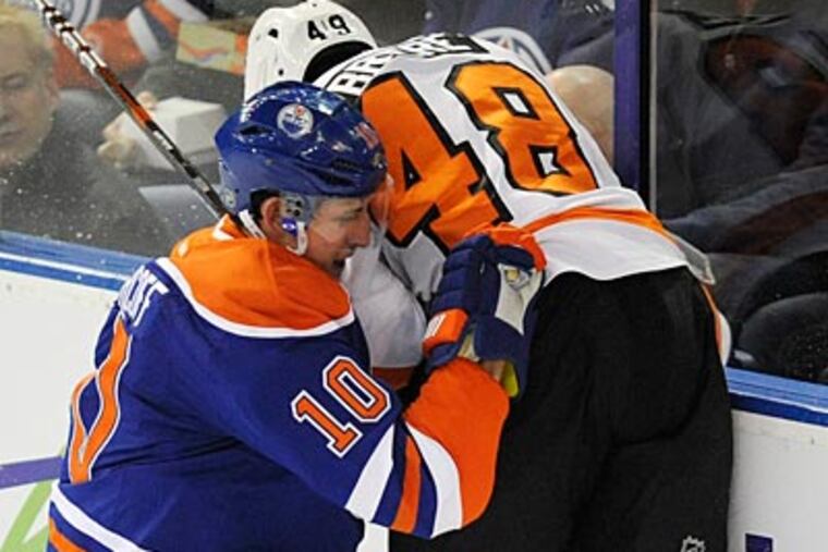 Danny Briere gets checked into the boards by the Oilers' Shawn Horcoff. (John Ulan/The Canadian Press/AP)