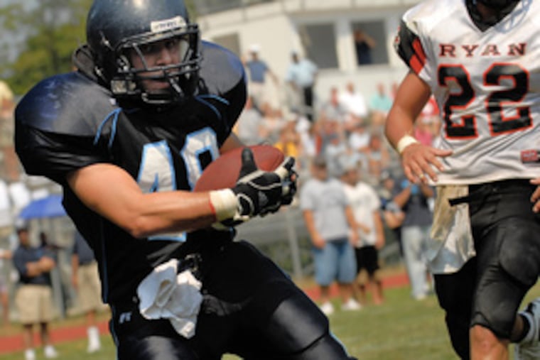 Chestnut Hill Academy's Mike Wismer (left) pulls in a touchdown pass in the second half as Archbishop Ryan defender Nick Ferdinand (22) trails. Wismer caught two TD passes.