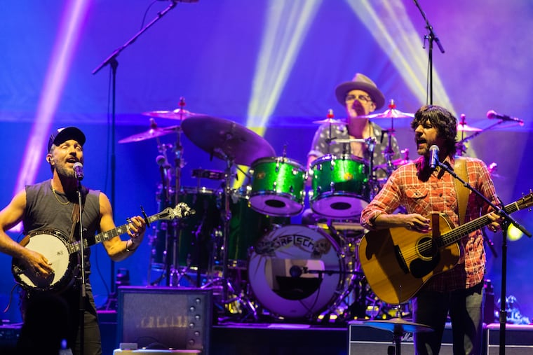 Scott Avett, left, and Seth Avett of the Avett Brothers Band perform at the Mann Center in 2023. Drummer Jacob Edwards is center. The band will play Hershey Park Stadium on June 13 as part of the free America 250PA Commonwealth Concert Series announced by Gov. Josh Shapiro on THursday.