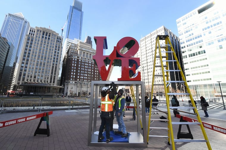 Workers bolt in the LOVE sculpture to JFK Plaza on February 13, 2018.