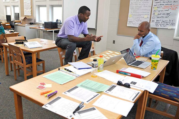 File photo: Tim Jenkins (left), MetEast High School principal, and Darrell Staton, lead educator, participate in a summer institute focused on developing lesson plans, coaching teachers.