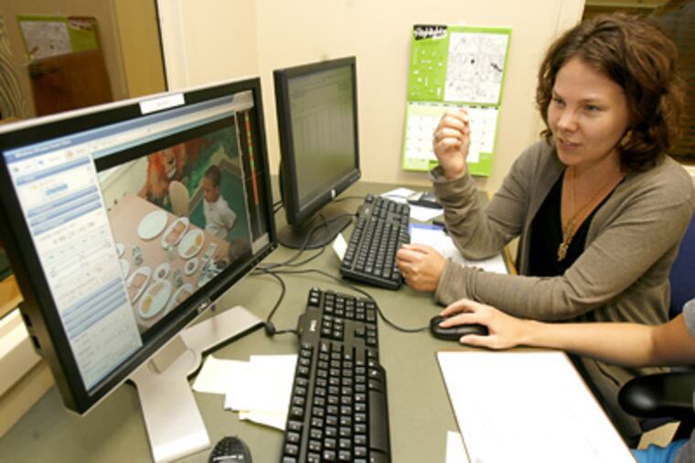 Jennifer Orlet Fisher watches a tape at Temple’s Family Eating Laboratory, where food has been measured and manipulated, and children’s choices analyzed. (Charles Fox / Staff Photographer)