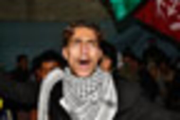 Palestinians celebrate as they wait at Rafah crossing border for released Palestinian prisoners to cross into Rafah, southern Gaza Strip, Sunday Dec. 18, 2011. Israel was wrapping up preparations to release 550 Palestinian prisoners late Sunday, in the second and final phase of a swap with Hamas militants that brought home an Israeli soldier after five years in captivity. (AP Photo/Adel Hana)